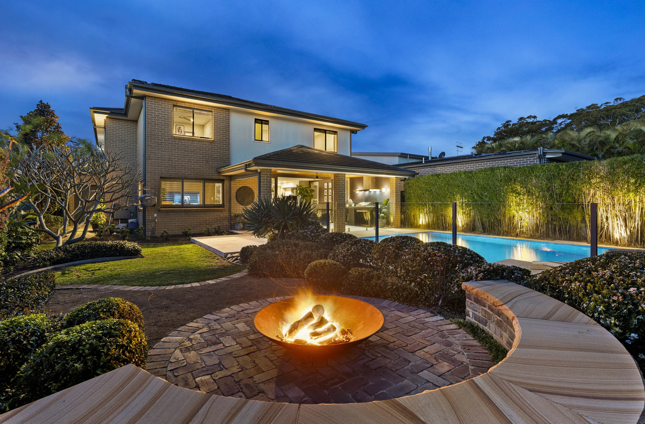 Private rear garden, firepit and swimming pool at twilight